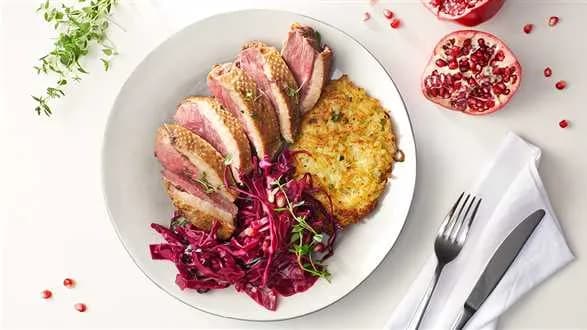 Wędzone piersi gęsi z placuszkami rosti i kapustą z granatem